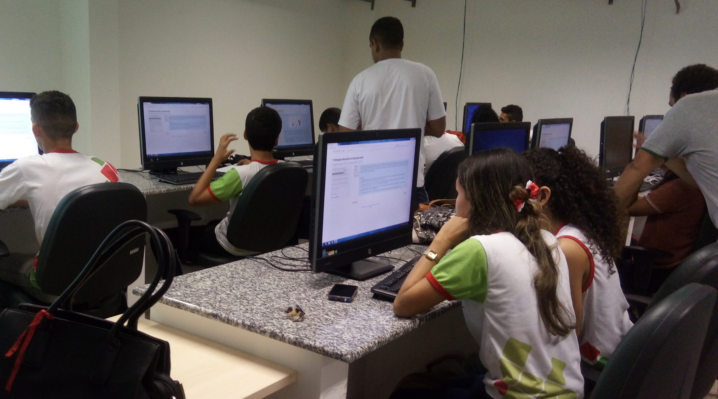 Estudantes usando computador no laboratório de informática